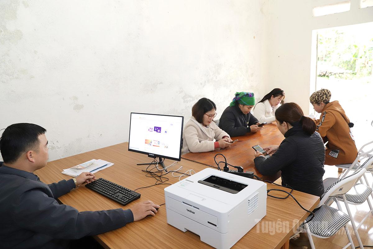 Members of the commune’s community digital technology team guide village officials in using computers and printers.