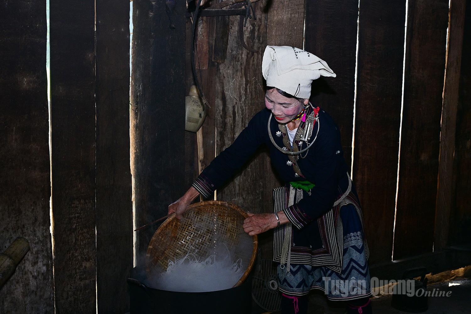 After the noodle strands are boiled, they are rinsed in a basket and lifted out.