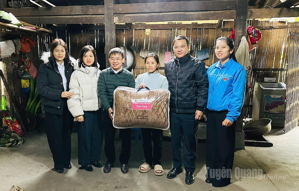 Đại diện Ngân hàng Nông nghiệp và Phát triển nông thôn chi nhánh Tuyên Quang tặng quà cho các gia đình có hoàn cảnh khó khăn thôn Phia Chang xã Hồng Thái.