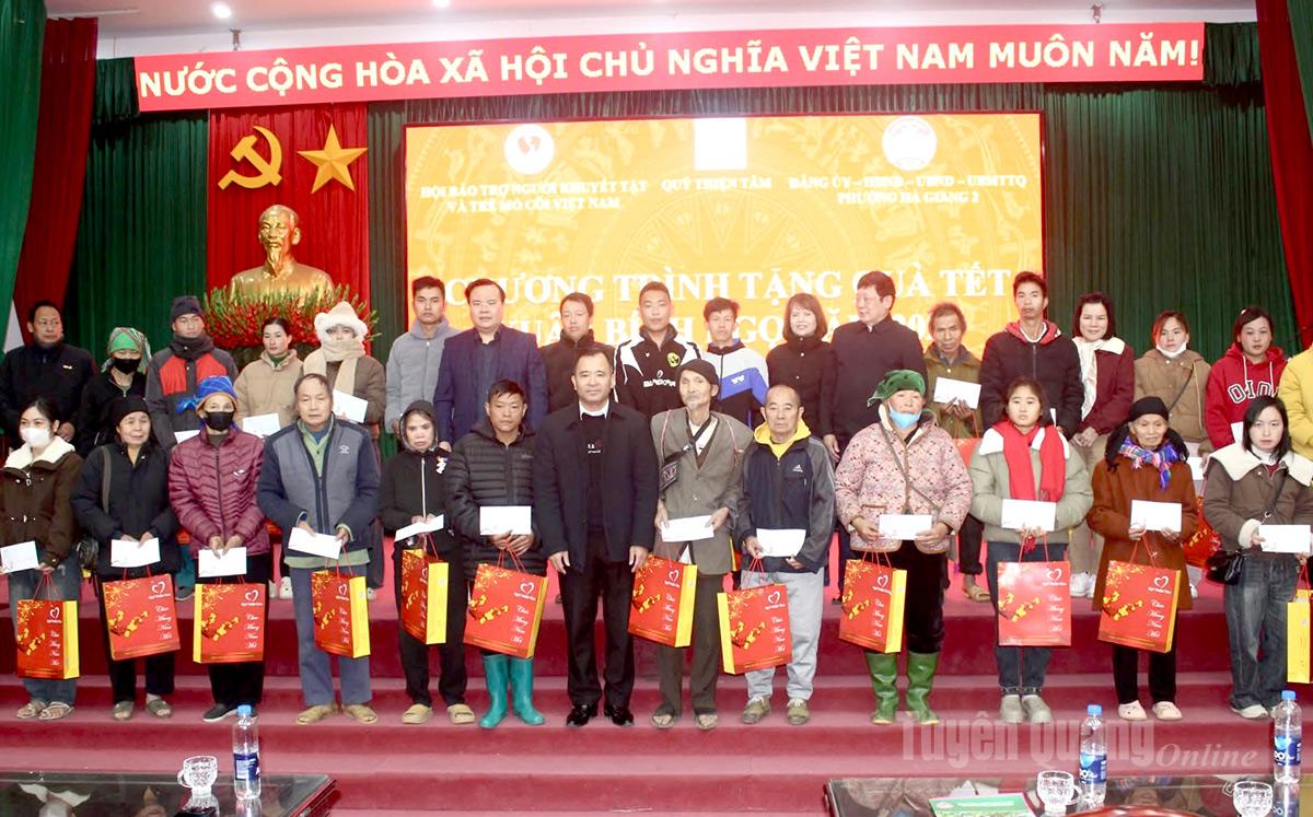 Đại diện Hội Bảo trợ người khuyết tật và trẻ mồ côi Việt Nam, Quỹ Thiện Tâm trao quà cho các hộ gia đình khó khăn.