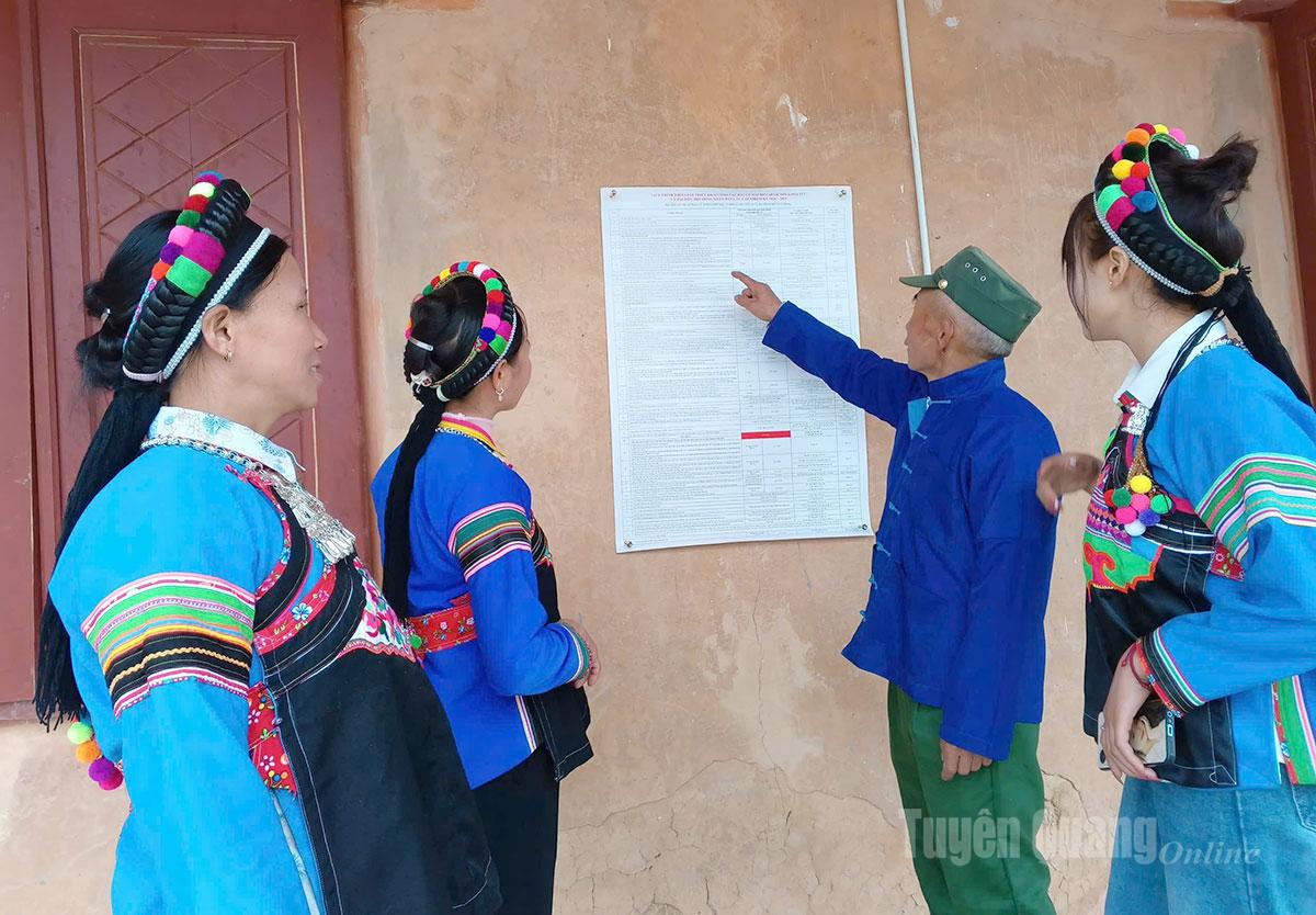  Đồng bào dân tộc Phù Lá ở thôn Chúng Trải, xã Xín Mần xem các mốc thời gian và nội dung liên quan đến cuộc bầu cử.