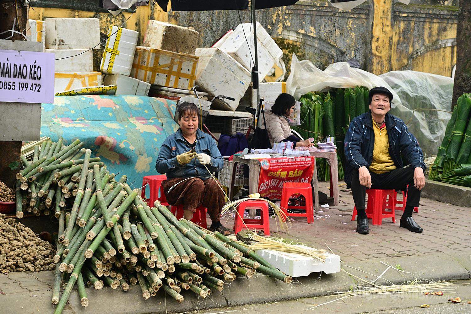 A vendor splits bamboo strips for sale at a corner of Tam Co Market.