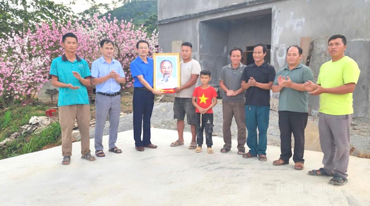 Lãnh đạo UBND xã Yên Minh tặng ảnh Bác Hồ, cờ Tổ quốc cho hộ xóa nhà tạm.