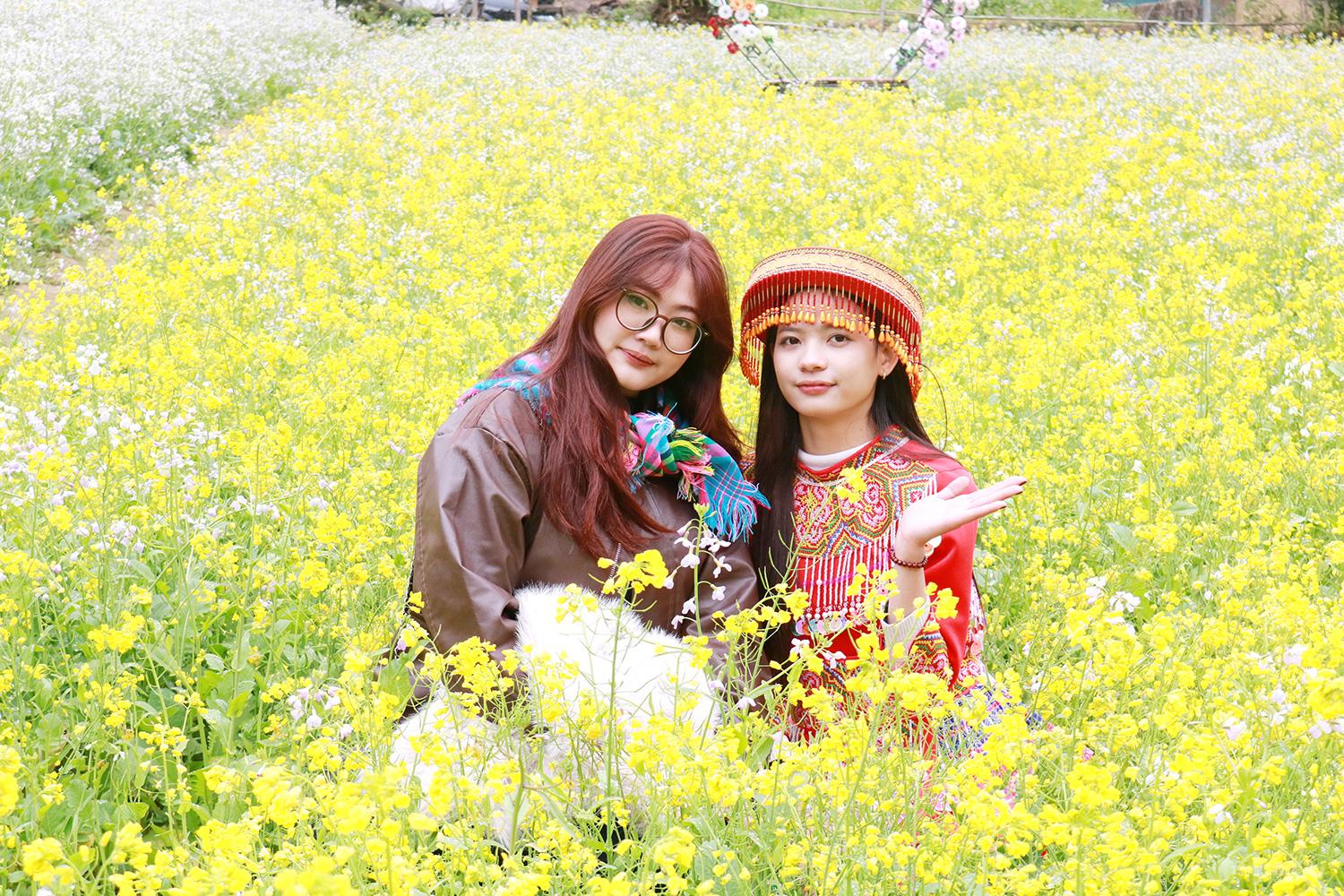 Tourists take photos at the flower fields of Lung Cam Tren hamlet.