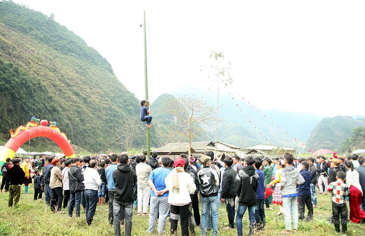 Du khách nước ngoài trải nghiệm trò chơi leo cột.