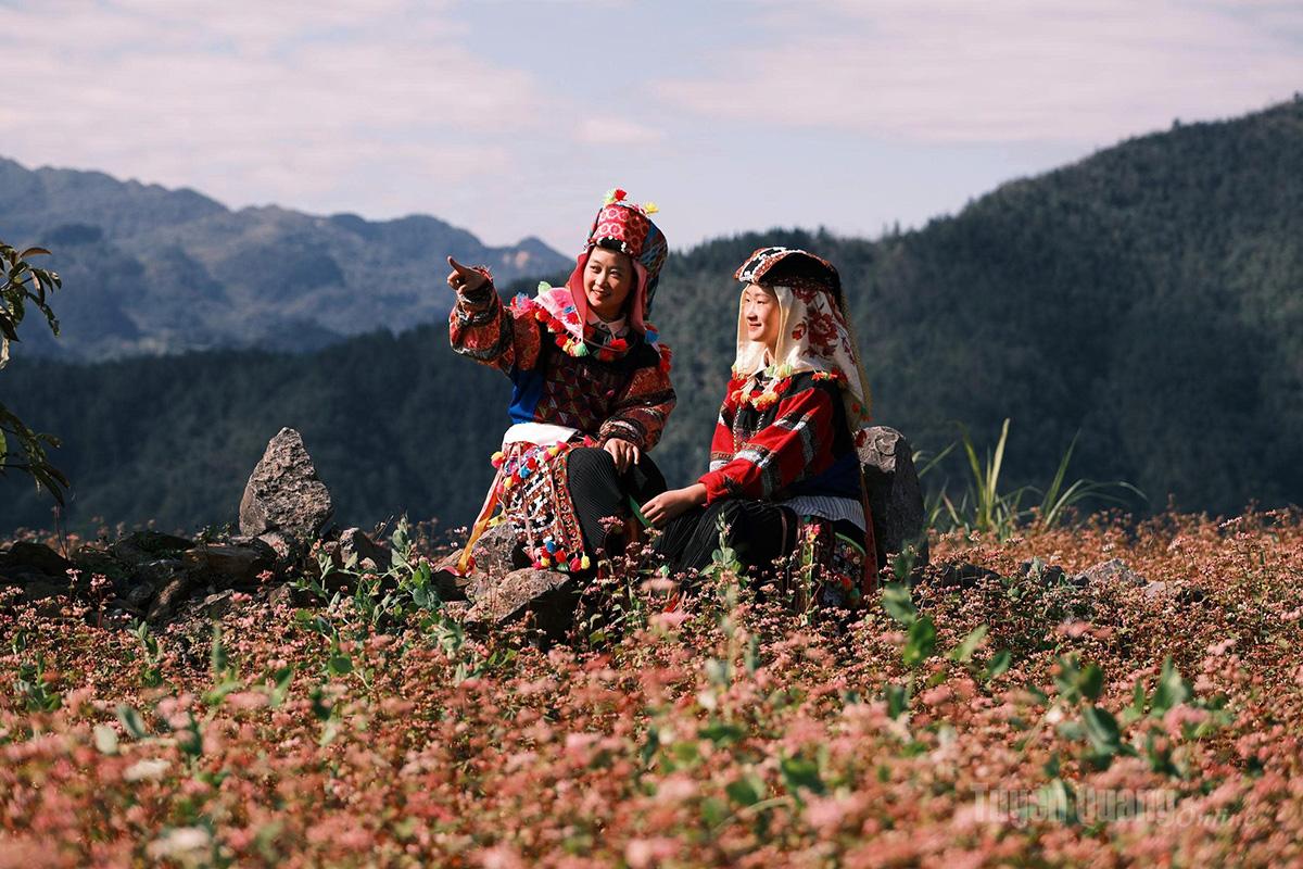 The radiant smiles of Lo Lo ethnic girls shine amid the rocky landscape and the colors of spring blossoms.