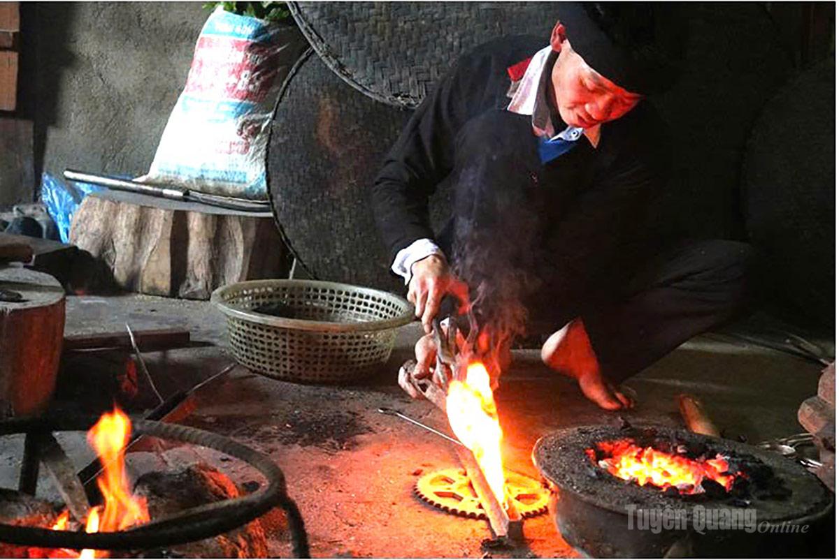 Chú thích: Nghệ nhân người Dao xã Cao Bồ thực hiện công đoạn đổ khuôn bạc sau khi nung chẩy trong lò thủ công.