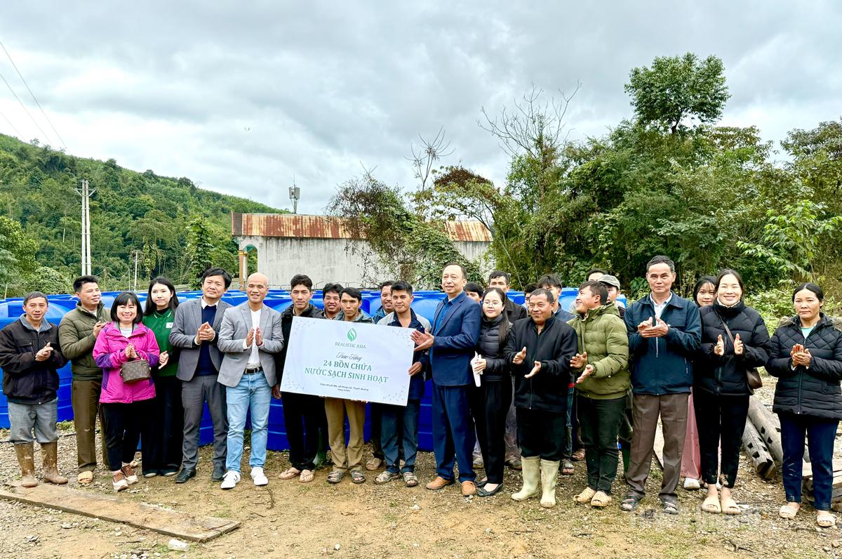 Các đại biểu trao biểu trưng bồn chứa nước sinh hoạt cho bà con thôn Khuổi Ma, xã Hùng Lợi.