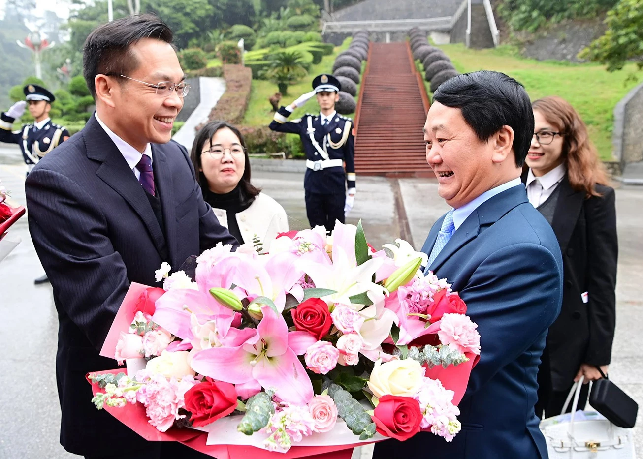 Comrade Pang Xuan Trieu, Vice Mayor of the People’s Government of Baise City, presents flowers to welcome Comrade Hau A Lenh, Member of the Party Central Committee and Secretary of the Tuyen Quang Provincial Party Committee, and the Tuyen Quang provincial delegation.