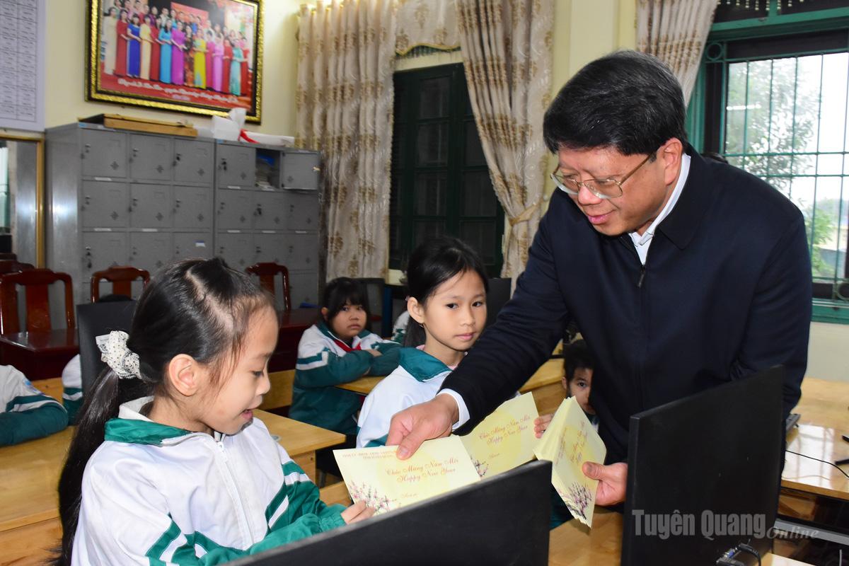 Đồng chí Hà Trung Kiên, Phó Chủ tịch Thường trực Uỷ ban MTTQ tỉnh trao quà của Tập đoàn Công nghiệp Năng lượng Quốc gia Việt Nam cho các em học sinh trường Tiểu học Ỷ La.