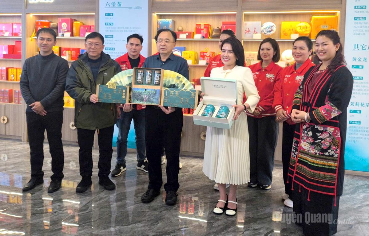 Giám đốc Trung tâm Quản lý Dự án Nông nghiệp sử dụng vốn nước ngoài tỉnh Quảng Tây và Trung tâm Khuyến công – Xúc tiến Công thương tỉnh trao tặng quà là sản phẩm chè của 2 địa phương.