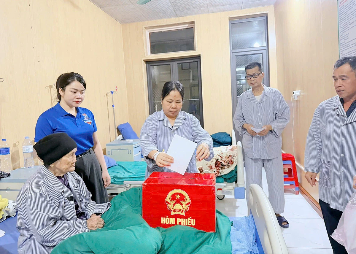 Các cử tri là bệnh nhân đang điều trị tại Bệnh viện ĐKKV Bắc Quang bỏ phiếu hòm phiếu phụ của tổ bầu cử số 2 xã Bắc Quang. Ảnh Hồng Cừ