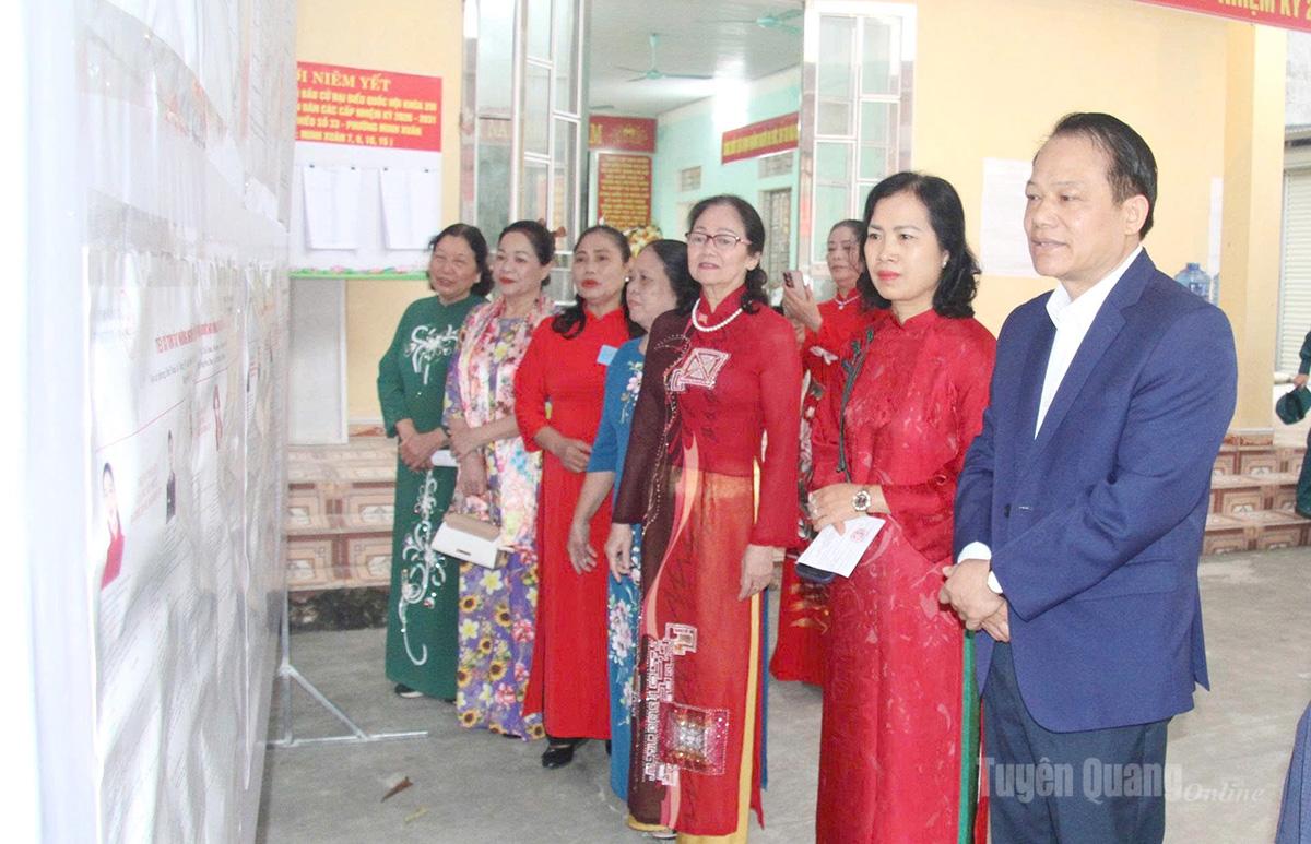 Đồng chí Vân Đình Thảo, Ủy viên Ban Thường vụ Tỉnh ủy, Trưởng ban Quản lý các khu công nghiệp và khu kinh tế tỉnh cùng cử tri theo dõi danh sách, tiểu sử các ứng cử viên tại Khu vực bỏ phiếu số 33, Nhà văn hóa tổ 9, 10, phường Minh Xuân. Ảnh: Mai Dung.