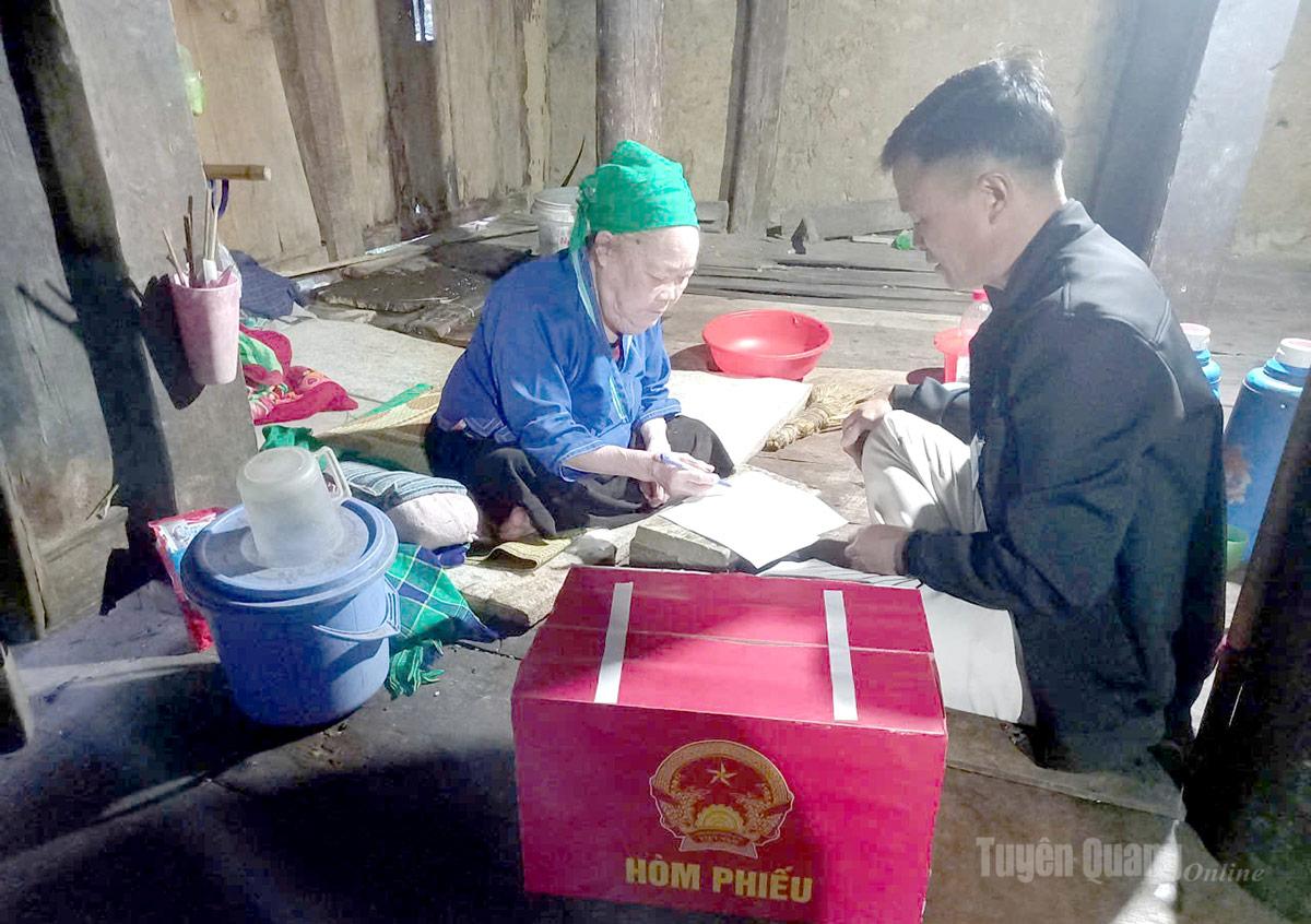 Cử tri cao tuổi xã Nấm Dẩn được tổ bầu cử xã hỗ trợ bỏ phiếu tại nhà bằng hòm phiếu phụ. Ảnh Hồng Nhung