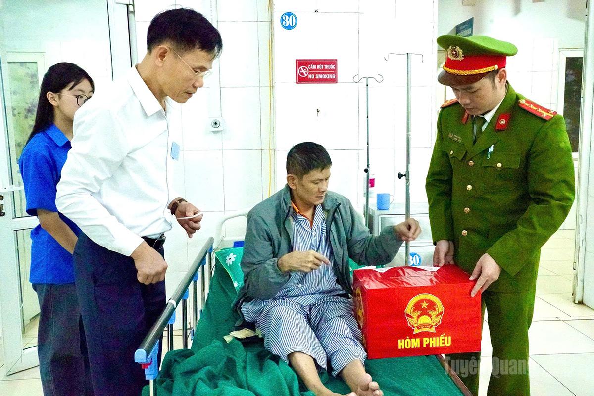 Công an phường Hà Giang 2 mang hòm phiếu phụ đến tận giường bệnh cho cử tri bỏ phiếu (ảnh chụp tại Bệnh viện Đakhoa Hà Giang). Ảnh: Khánh Huyền