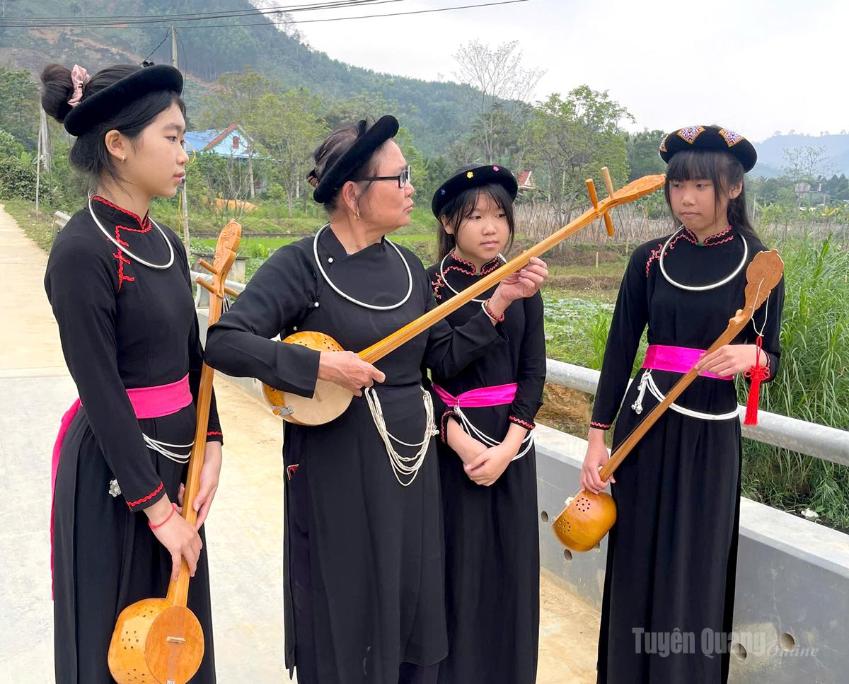 Bà Mỵ tỉ mỉ hướng dẫn các cháu học sinh cách đánh đàn Tính.