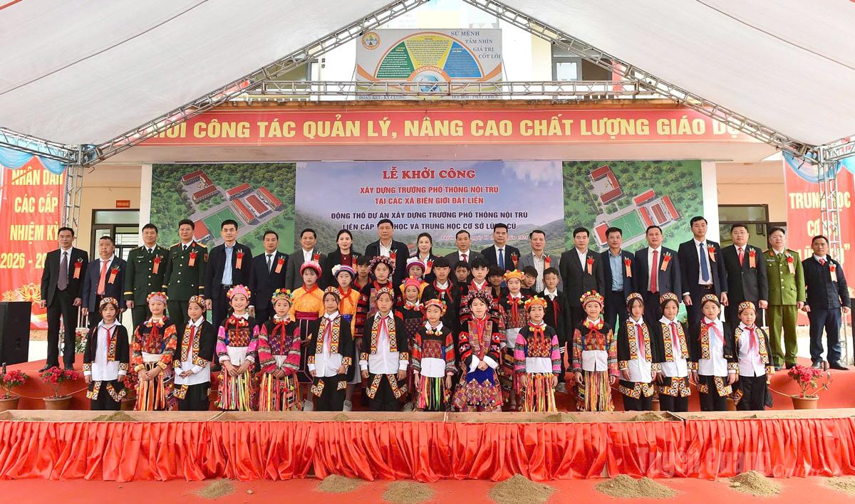 Các đại biểu và các em học sinh chụp ảnh lưu niệm.