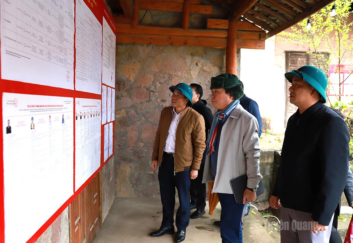 Đồng chí Mai Đức Thông, Giám đốc Báo và phát thanh, truyền hình Tuyên Quang kiểm tra danh sách đại biểu niêm yết tại điểm bầu cử thôn Lô Lô Chải, xã Lũng Cú.