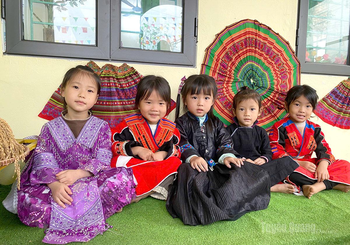 2. Trong căn phòng học rộn ràng tiếng cười, các em nhỏ khoác lên mình những bộ trang phục dân tộc rực rỡ.