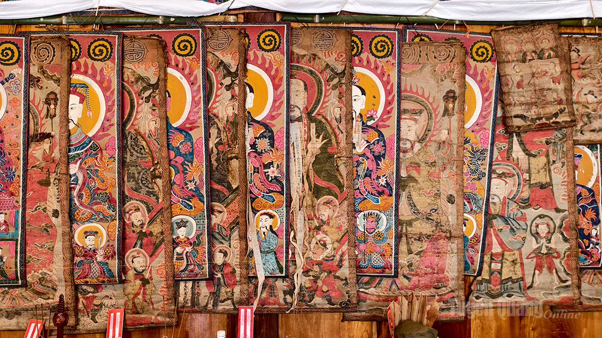 After completing the rites to worship ancestors and deities, the ritual master and his assistants hang sacred paintings and set up frames to display the ceremonial documents (sacred petitions) of the initiates. These documents contain detailed information such as full name, date and time of birth, and the names of family members.