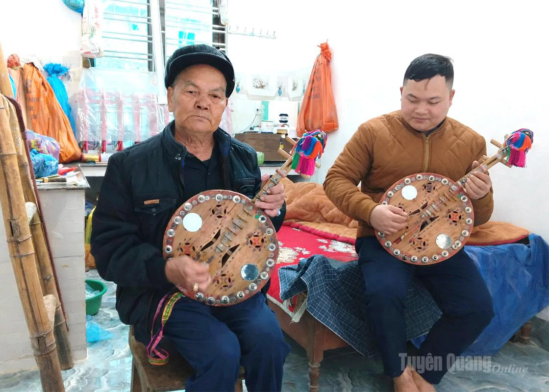 Artisan Vang Van Seng (left) teaches young people how to play the Lin Xin.