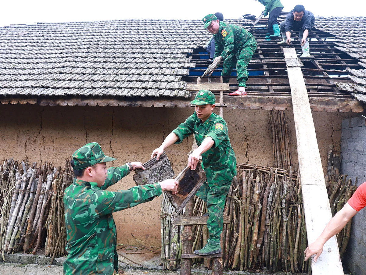 Cán bộ, chiến sĩ Đồn Biên phòng Tùng Vài giúp người dân khắc phục hậu quả thiên tai.