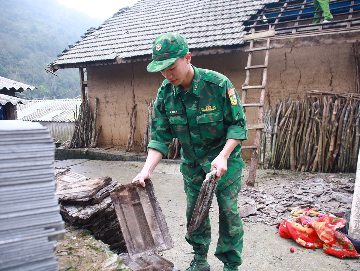 Chiến sĩ Lý Hoàng Vũ hỗ trợ người dân tháo dỡ, sắp xếp những viên ngói bị vỡ do mưa đá.