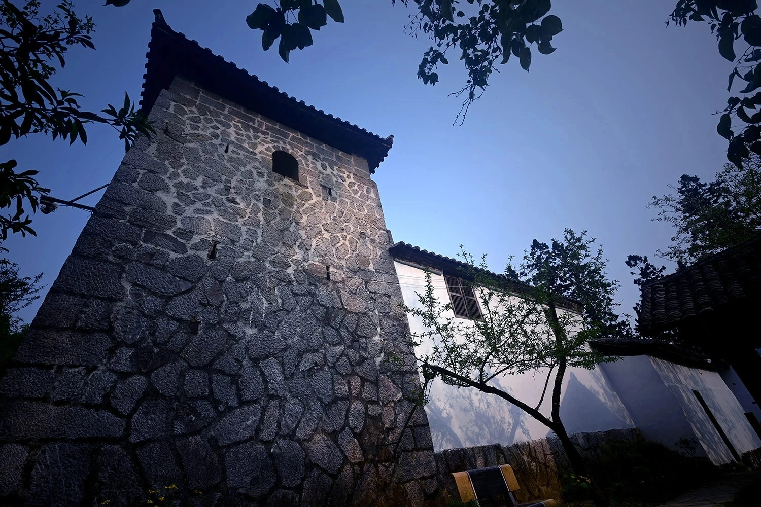 The surrounding walls are built of stone, the roofs are covered with yin-yang tiles, and the structural framework is made from rare stone pine wood.