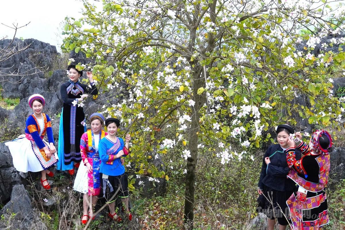 Young women in colorful traditional attire eagerly attend the ban flower festival.