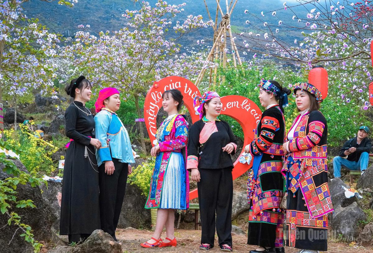 The girls stand out vividly against the backdrop of blooming ban flowers.