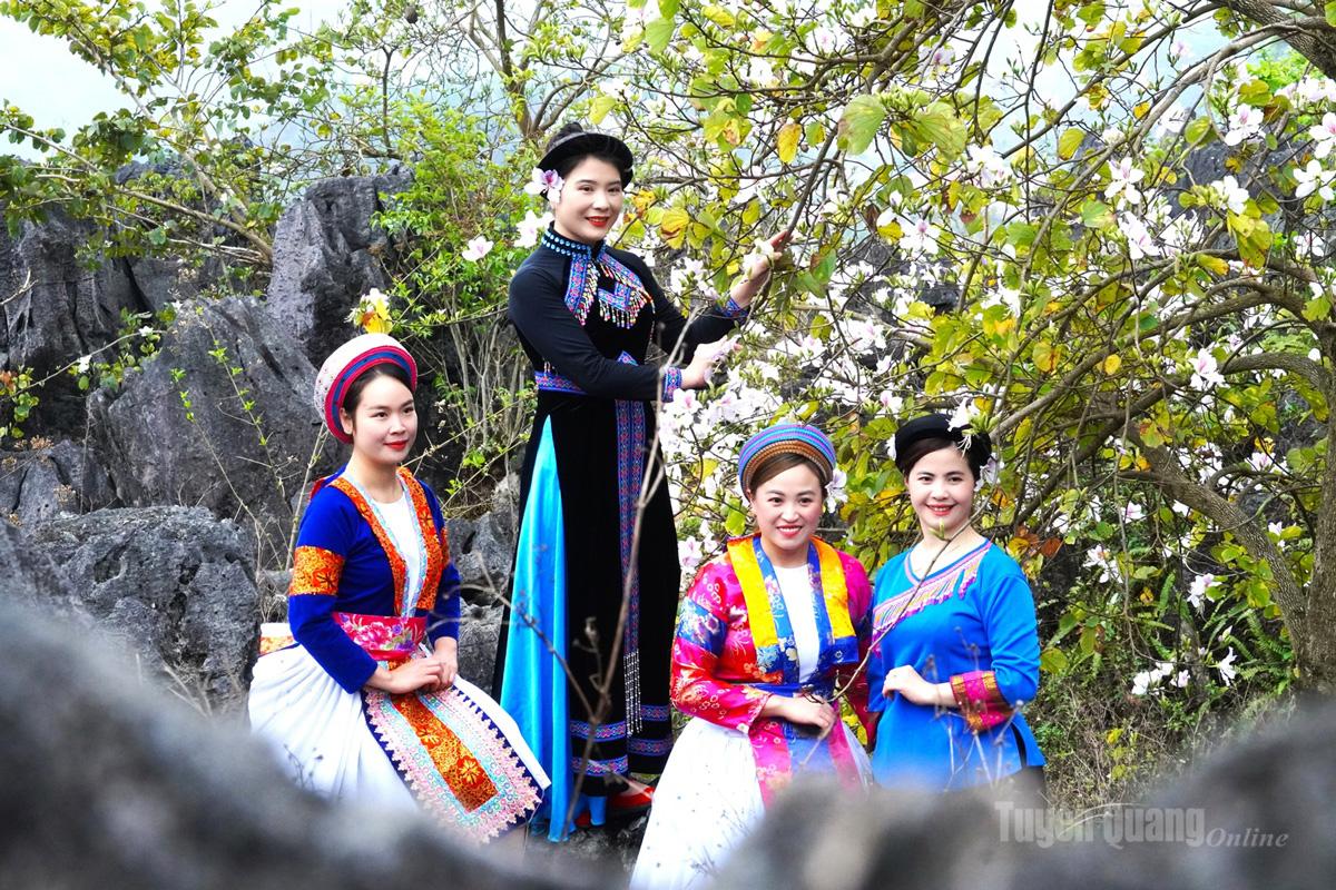 Indigo tones, brocade patterns, and the colors of ban flowers together paint a spring scene rich in cultural identity.