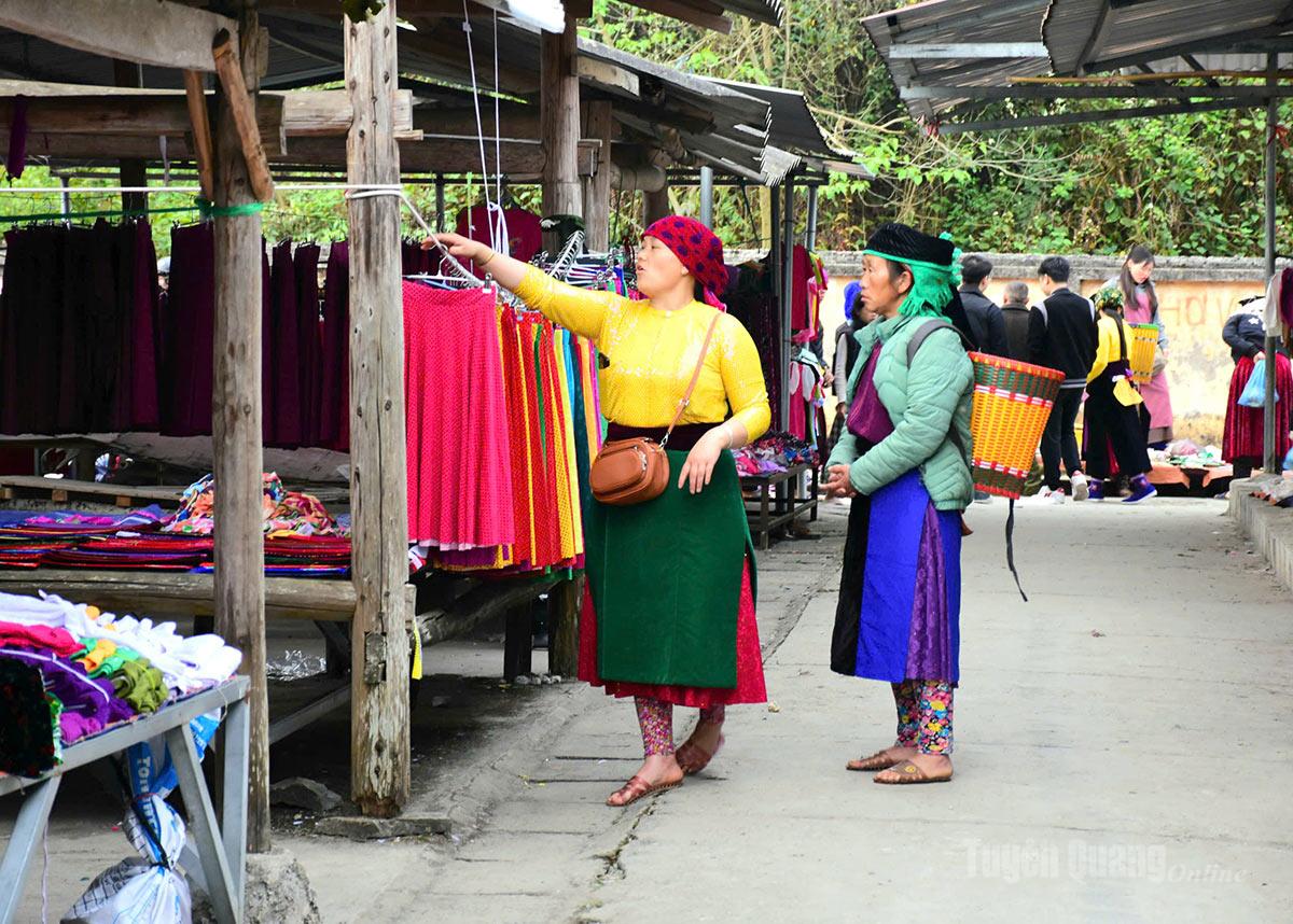 People select traditional ethnic clothing at the market.