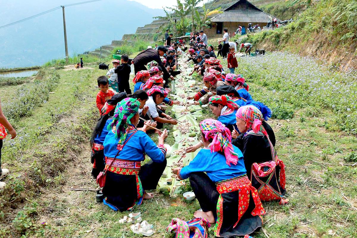 After the ceremonial and festive activities conclude, villagers gather around traditional feasts in the mountainous setting, sharing communal meals to celebrate the spring festival.