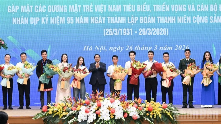 Prime Minister Pham Minh Chinh presents flowers to outstanding young people. (Photo: NDO)