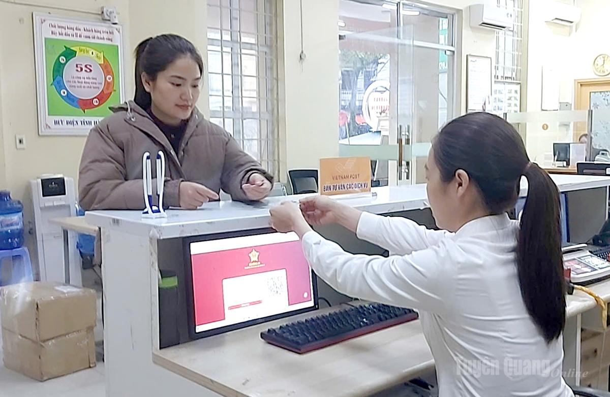 Nhân viên Bưu cục Bắc Quang, thuộc Bưu điện xã Bắc Quang hỗ trợ người dân giải quyết thủ tục hành chính trên môi trường điện tử.