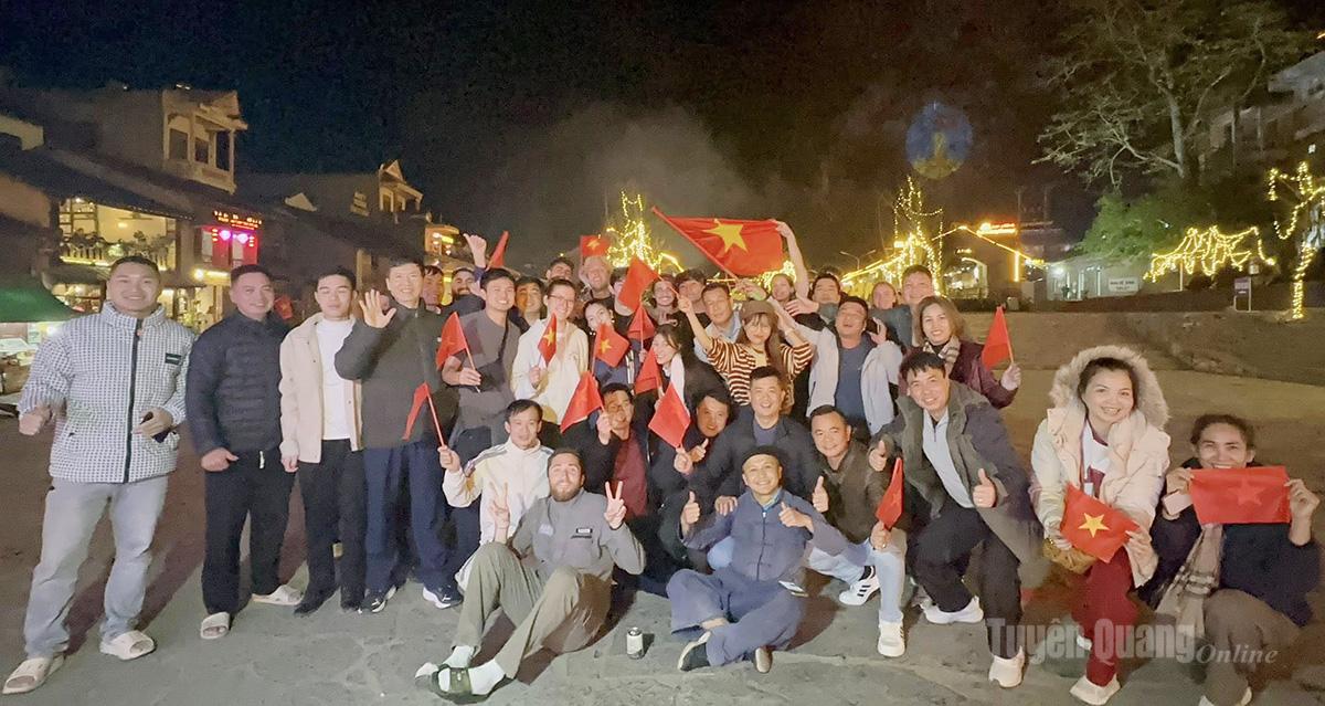 Người giữ lửa phố cổ Đồng Văn Sùng Mạnh Hùng cùng du khách ở phố cổ Đồng Văn.