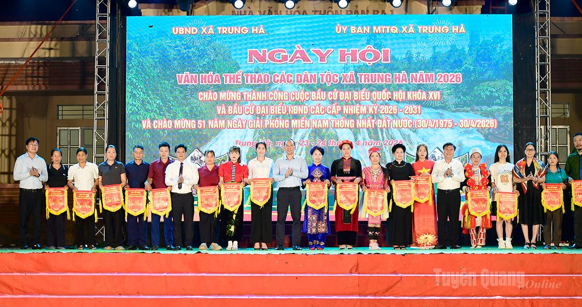 Đồng chí Mai Đức Thông, Ủy viên BCH Đảng bộ tỉnh, Giám đốc Báo và phát thanh, truyền hình Tuyên Quang, Chủ tịch Hội Nhà báo tỉnh và lãnh đạo xã Trung Hà tặng cờ lưu niệm cho các thôn tham gia ngày hội.