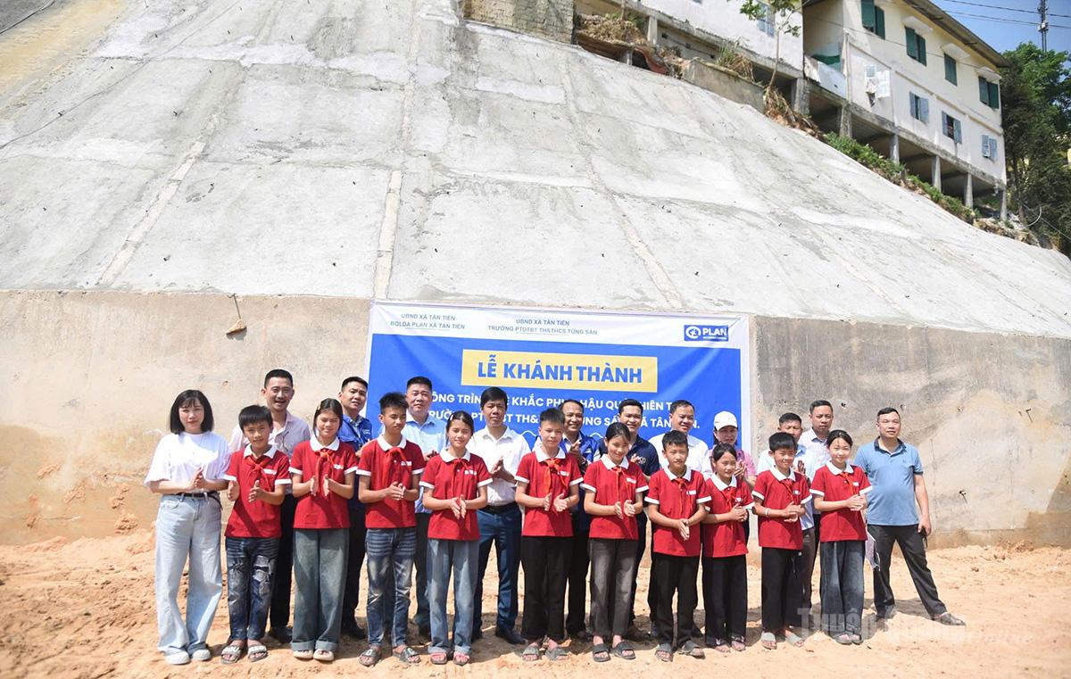 Các đại biểu, thầy cô và học sinh trường PTDT bán trú TH&THCS Túng Sán tại Lễ khánh thành công trình kè khắc phục hậu quả thiên tai do Tổ chức Plan hỗ trợ.