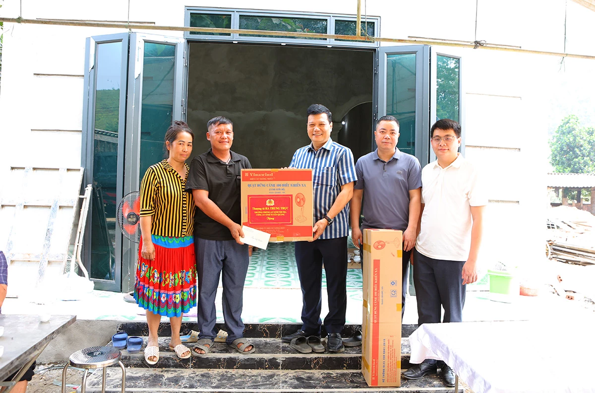Thượng tá Hà Trung Trực, Trưởng Phòng ANNĐ Công an tỉnh (đứng giữa) trao tặng quà vào nhà mới cho người dân xã Yên Phú.