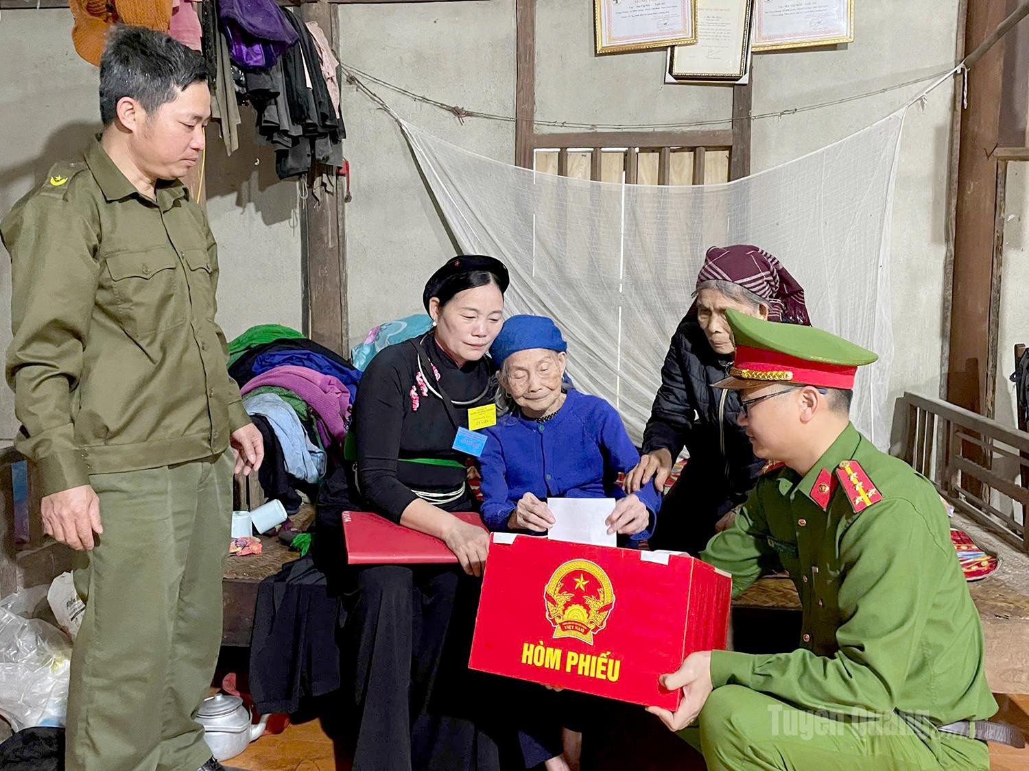 Tổ bầu cử xã Minh Quang, hỗ trợ cử tri Ma Thị Hói, 104 tuổi, thôn Noong phường bỏ phiếu tại nhà bằng hòm phiếu phụ.