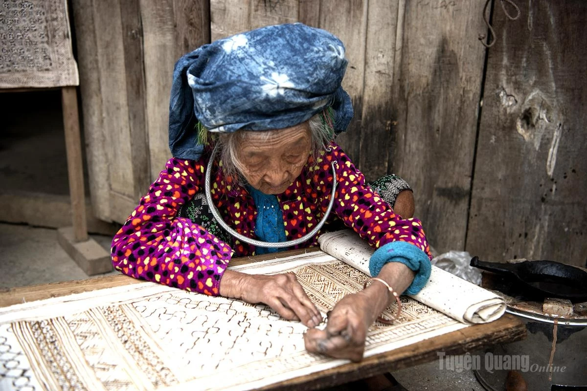 A Mong artisan carefully applies beeswax on hemp fabric, creating distinctive traditional patterns of the Mong ethnic group.