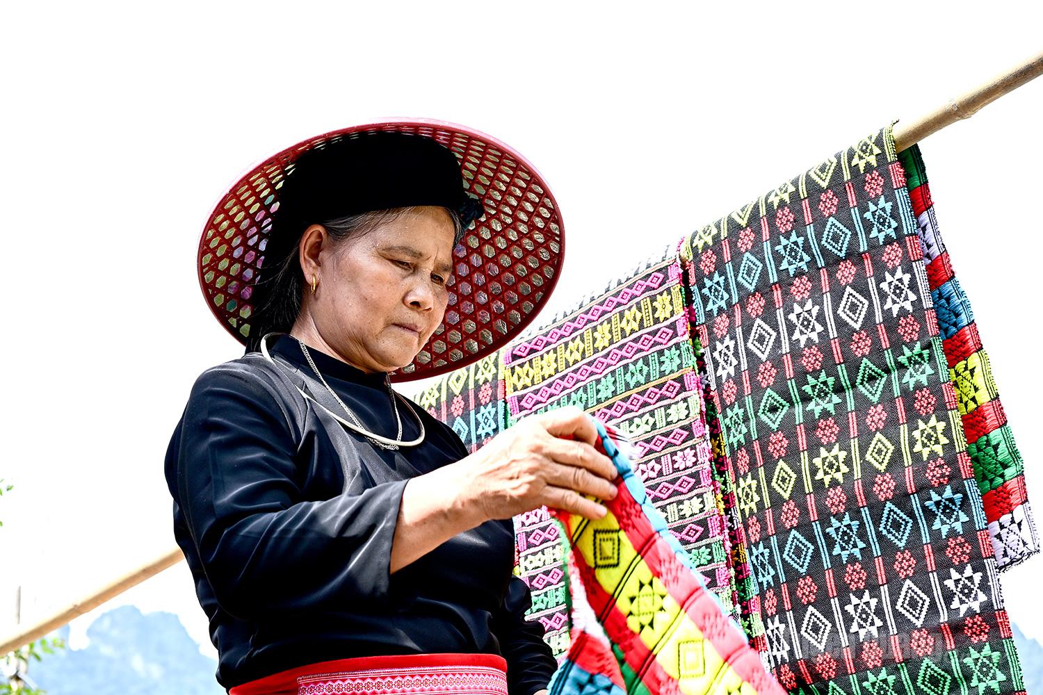 Under the scorching sun, residents take the opportunity to dry clothes while making sure to wear hats for protection.
