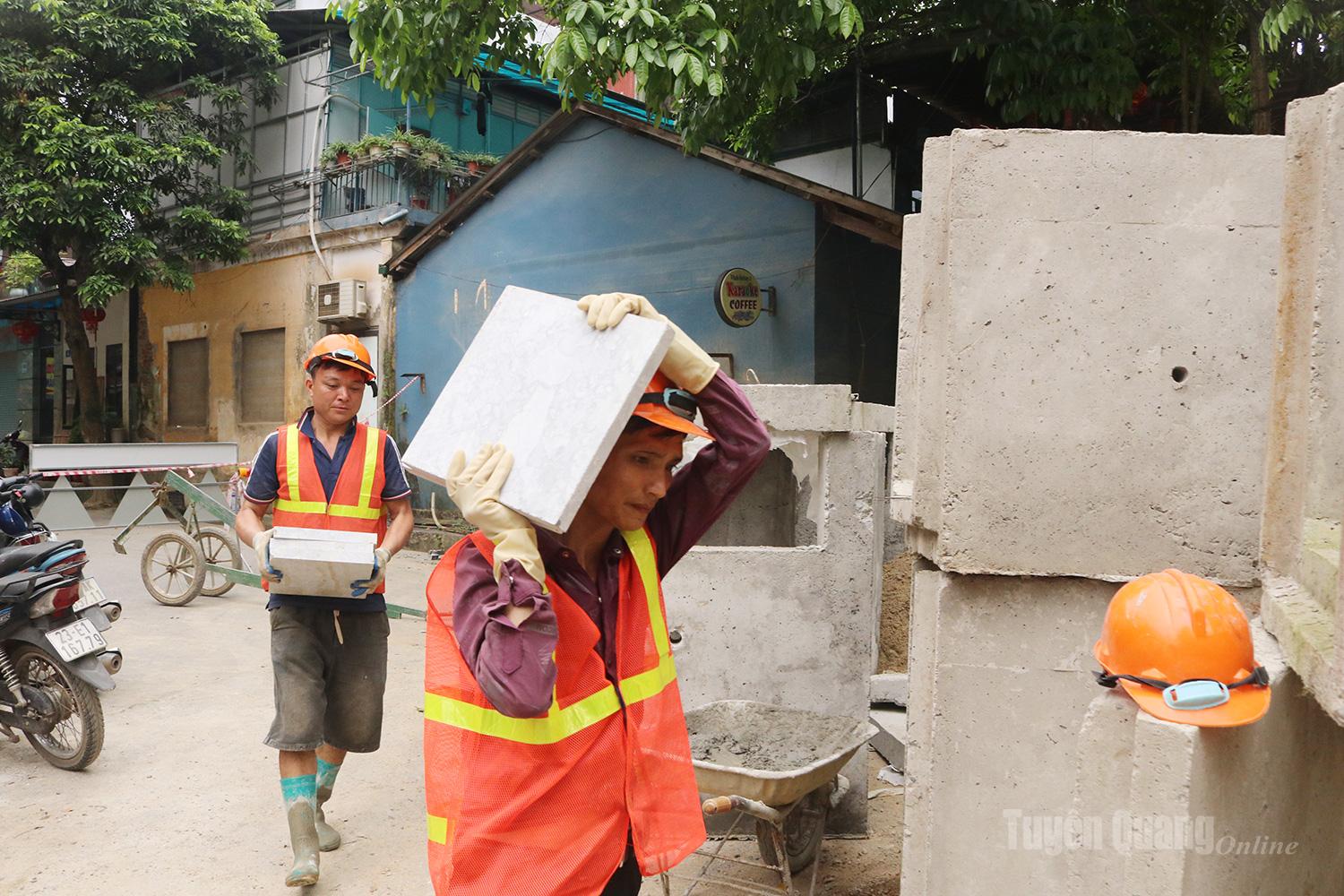 Workers are transporting concrete components to serve the development of urban infrastructure.
