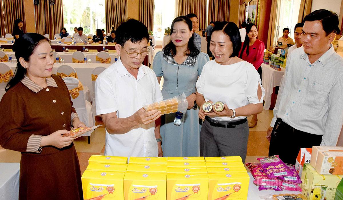 Phó Giám đốc Sở Công Thương tỉnh Tuyên Quang Lộc Kim Liễn (thứ hai, từ trái qua) và Phó Giám đốc Sở Công Thương tỉnh An Giang Nguyễn Duy Linh Thảo (thứ hai, từ phải qua) trao đổi về sản phẩm đặc trưng của hai tỉnh An Giang và Tuyên Quang.