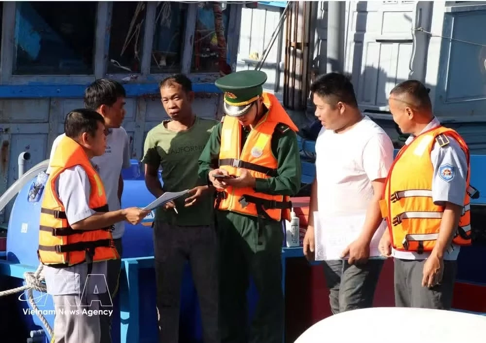 Officers from the Ca Na border guard station and the management board of Ca Na fishing port in Khanh Hoa province inspect documents related to fishermen’s vessels (Photo: VNA)