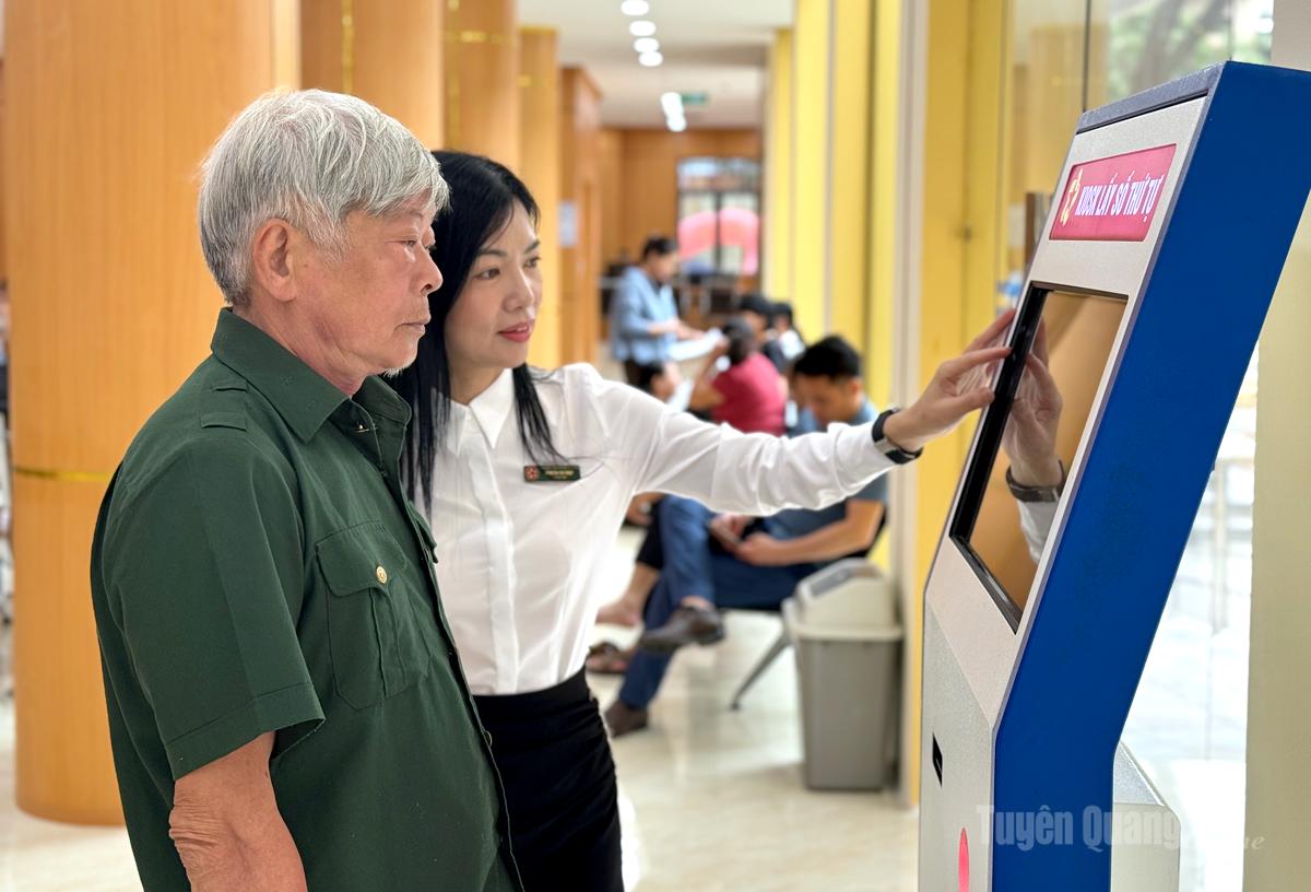 Cán bộ Trung tâm phục vụ hành chính công tỉnh tận tình hỗ trợ người dân lấy phiếu thứ tự để thực hiện các thủ tục hành chính.