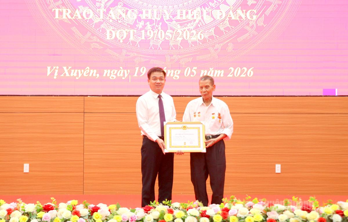 Đồng chí Nguyễn Hưng Vượng trao Huy hiệu 65 năm tuổi Đảng cho đảng viên Dương Xuân Bá, Chi bộ thôn Độc Lập, Đảng bộ xã Vị Xuyên.