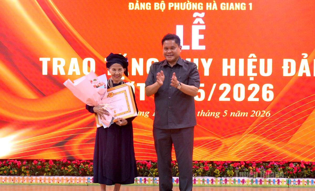 Ủy viên BTV Tỉnh ủy Vàng Seo Cón trao Huy hiệu 60 năm tuổi Đảng và tặng hoa chúc mừng đảng viên Cam Thị Sen.
