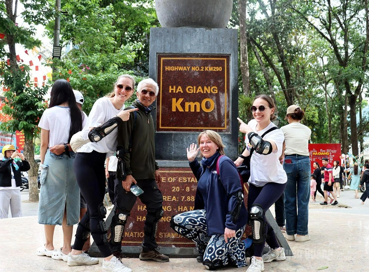 Foreign visitors take photos at the Km 0 Ha Giang symbol.