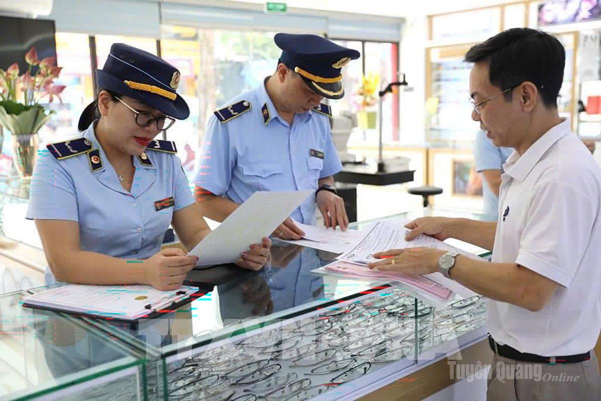 Kiểm soát viên Đội 6, Quản lý thị trường Tuyên Quang tuyên truyền và ký cam kết với hộ kinh doanh về việc bán hàng hóa có xuất xứ rõ ràng.